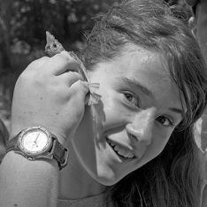 Girl listens to the heartbeat of bird with a naturalist/educator